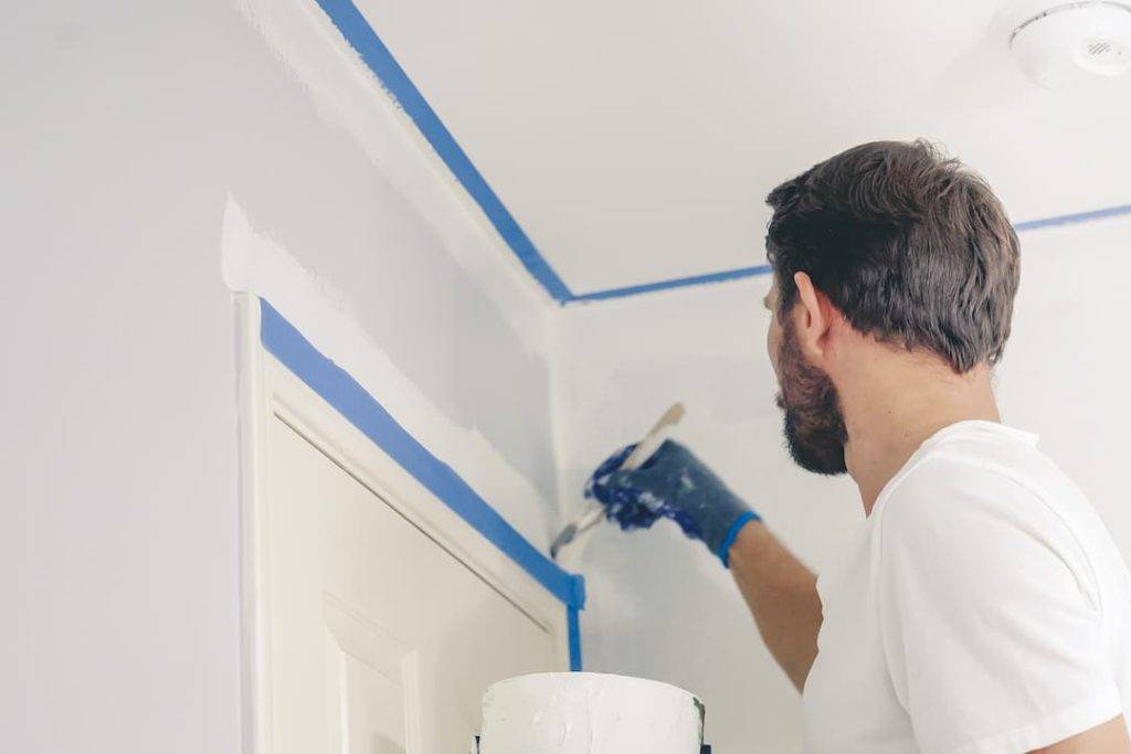 painter and decorator painting over a door frame